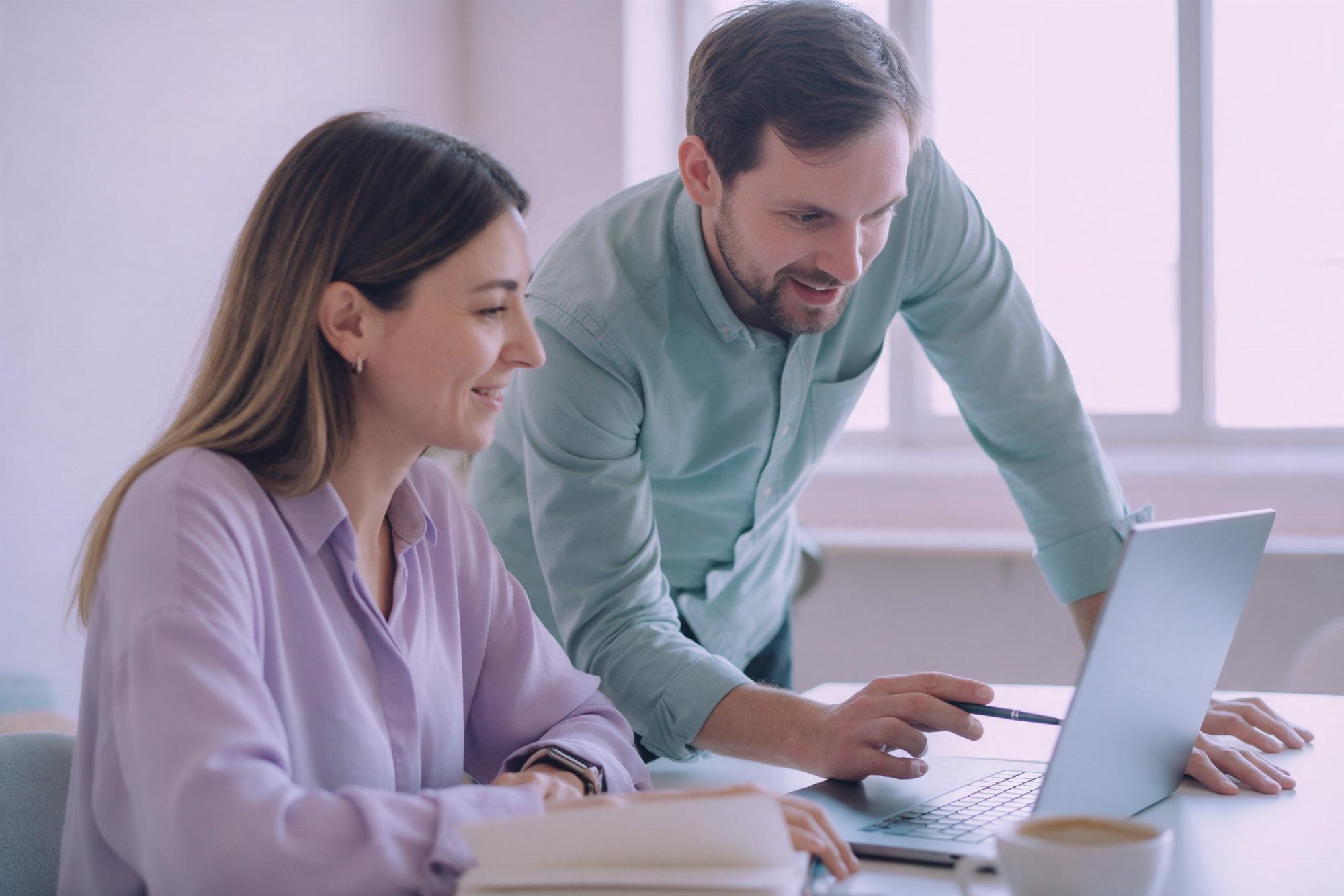 Two Webgentic consultants at a desk, one talking the other through a change on a laptop.